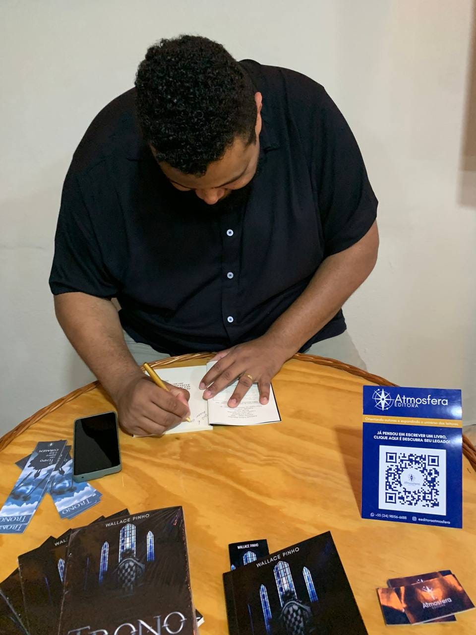 Wallace Pinho escrevendo uma dedicatória
